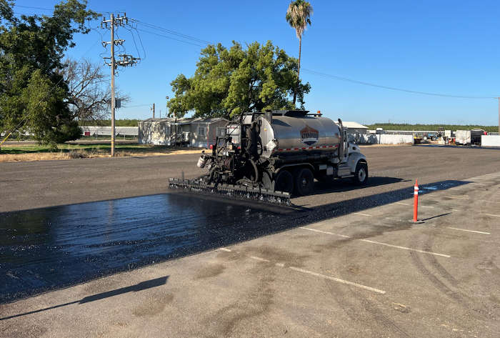 road oil being sprayed over asphalt millings