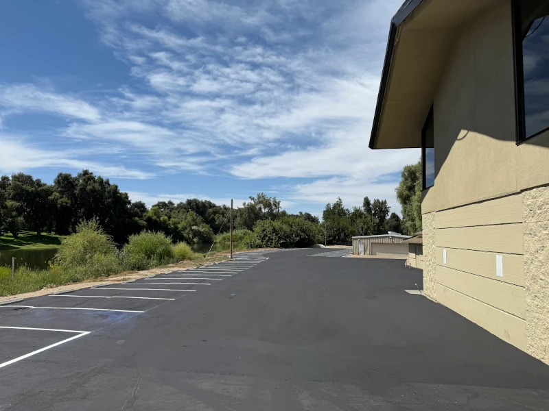 Backside of Kings River Golf & Country Club parking lot after it has been sealcoated and striped
