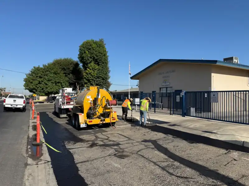 crew edging the parking lot before spraying coating