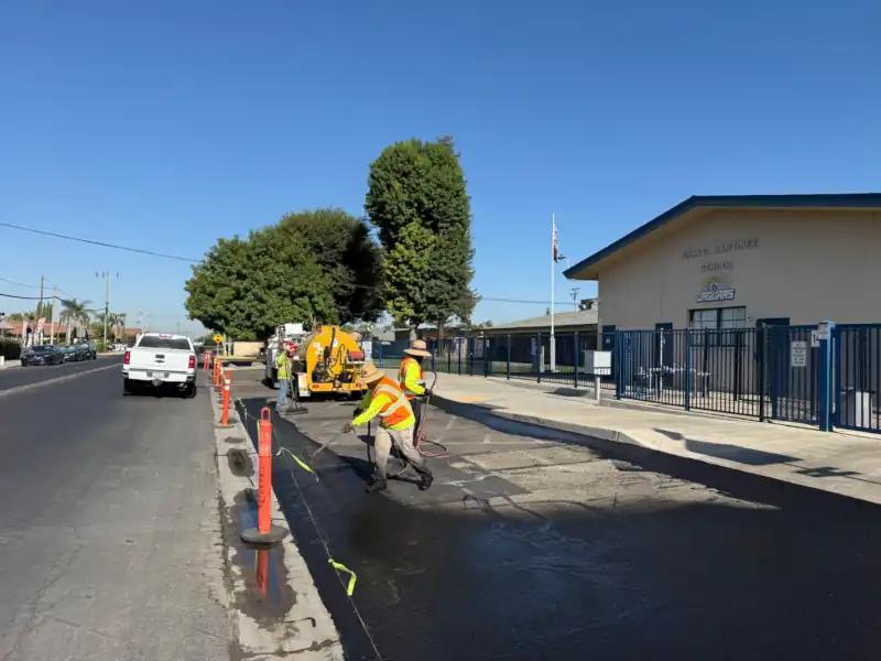 crew spraying asphalt coating